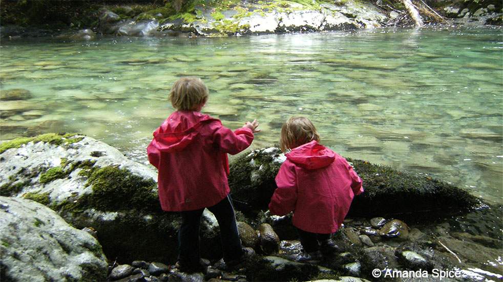 Backpacking with kids: children playing by a river